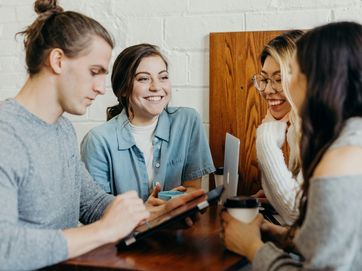 Forum Wissenschaftsmanagement Leibniz-Akademie für Führungskräfte Vier junge Menschen stehen um einen Tisch herum und unterhalten sich.